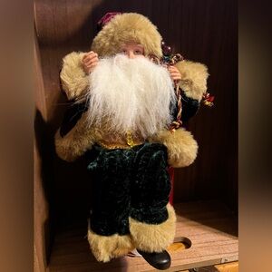 Vintage shelf sitting Santa with velvet clothes and toy bag.